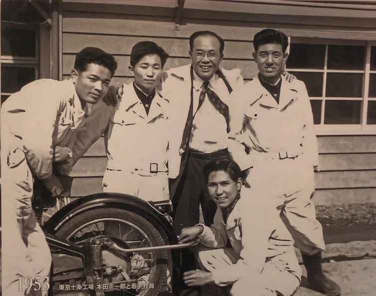 本田宗一郎与几位年轻员工围在一辆两轮车旁的合影，原图标注1953年东京大和工厂。